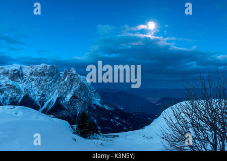 Seiser Alm, Dolomiten, Südtirol, Italien. Blaue Stunde auf der Hochebene von bullaccia/Puflatsch. Im Hintergrund der Gipfel des Schlern und die Lichter der Stadt Bozen Stockfoto
