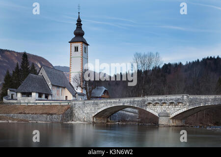 Europa, Slowenien, Obere Krain. Kirche Sv. Johannes der Täufer und die Steinerne Brücke von der Bohinj See Stockfoto