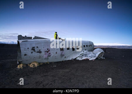 Mann auf der Oberseite des verlassenen US Navy DC Ebene am Strand von Solheimasandur, Sudurland, Island, Europa Stockfoto