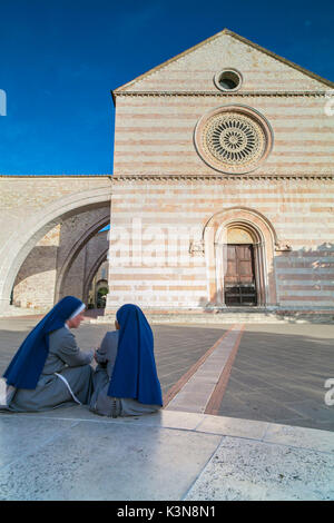 Die Kirchen von St. Klara, mit zwei Nonnen im Vordergrund, Umbrien Italien, Europa Stockfoto