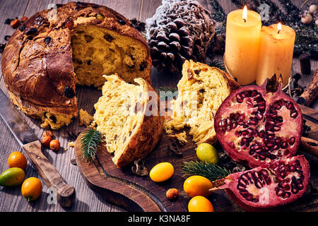 Traditionelle italienische Weihnachtskuchen mit Kerzen, Granatapfel und Winter Früchte, Panettone Stockfoto