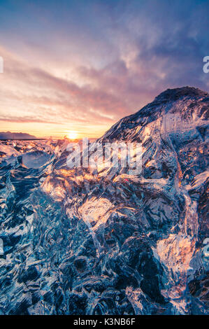 Gletscherlagune Jokulsarlon, Island. Sonnenlicht Reflexionen über ein kleines schwarzes Eis am Ufer. Stockfoto