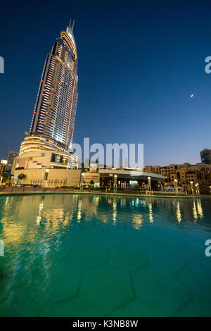 Die Wolkenkratzer von Hotel Adresse Downtown Dubai und der Burj Khalifa See von Dubai am Abend. Vereinigte Arabische Emirate Stockfoto