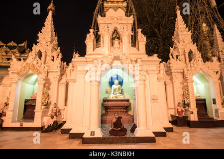 Yangon, Myanmar (Birma). Mönch beten in einer kleinen Stupa der Shwedagon Pagode in der Nacht. Stockfoto