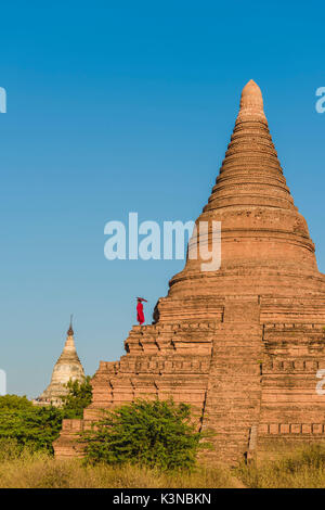 Bagan, Mandalay, Myanmar (Birma). Ein junger Mönch beobachten die Shwesandaw Pagode. Stockfoto