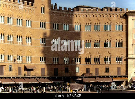 Der Schatten des Mangia Turm ist auf die Fassaden der alten Gebäude, die Piazza del Campo, Siena, Toskana, Italien Surround projiziert Stockfoto