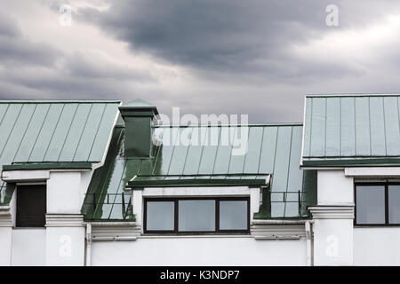 Graues Metall Dach mit Windows während der Regen gegen dunkle bewölkter Himmel Stockfoto