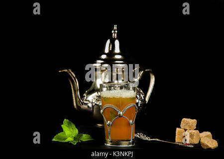 Wahre marokkanischen Minztee in der ursprünglichen Schale und Teekanne auf dem schwarzen Hintergrund Stockfoto