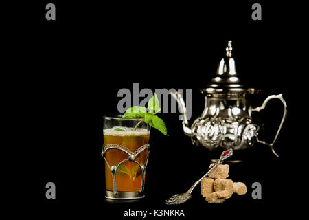 Wahre marokkanischen Minztee in der ursprünglichen Schale und Teekanne auf dem schwarzen Hintergrund Stockfoto