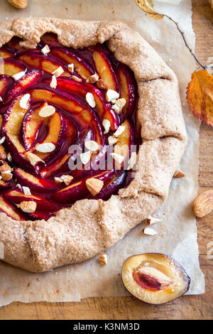 Pflaume Galette. Gesunde hausgemachtem Vollkorn Früchte Torte (Galette) mit Pflaumen, Mandeln, brauner Zucker, vegan vegetarisch Herbst Dessert essen. Stockfoto