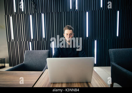 Erfolgreiche Unternehmer Arbeiten am Laptop in der modernen Luxus Büro Schreibtisch. Junge Unternehmer mit Arbeit Ergebnis der Analyse finanzieller Indikatoren zufrieden auf Stockfoto