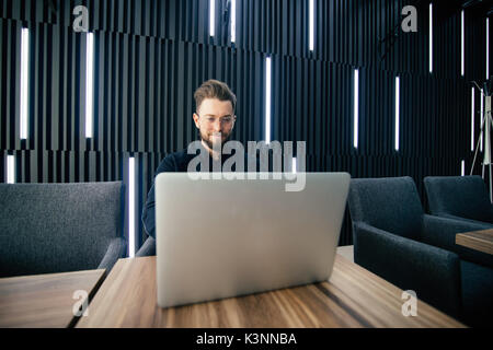 Erfolgreiche Unternehmer Arbeiten am Laptop in der modernen Luxus Büro Schreibtisch. Junge Unternehmer mit Arbeit Ergebnis der Analyse finanzieller Indikatoren zufrieden auf Stockfoto