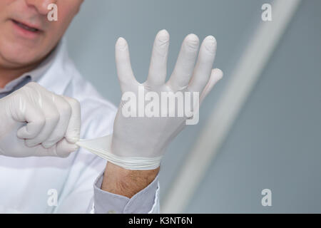 Arzt Schutzhandschuhe anziehen Stockfoto