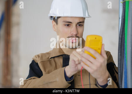 Mit Hilfe eines digitalen Multimeters isoliert Builder Stockfoto