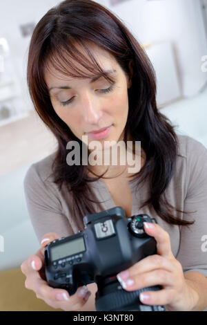 Glückliche Frau prüfen Fotos auf der Kamera Stockfoto