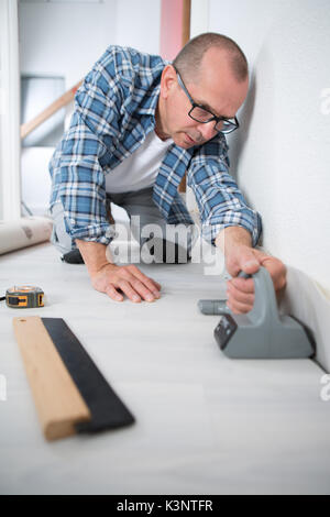 Kaufmann zur Festlegung von Linoleum Boden Stockfoto