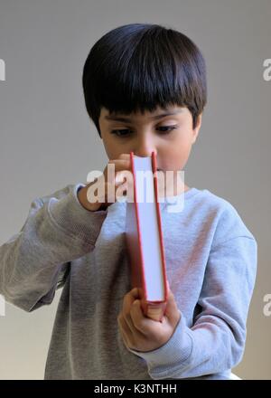 Kind ein Buch heraus überprüfen. Junge mit Buch. Stockfoto