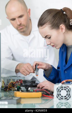 Weibliche Auszubildende Lernen ein Multimeter zu verwenden Stockfoto