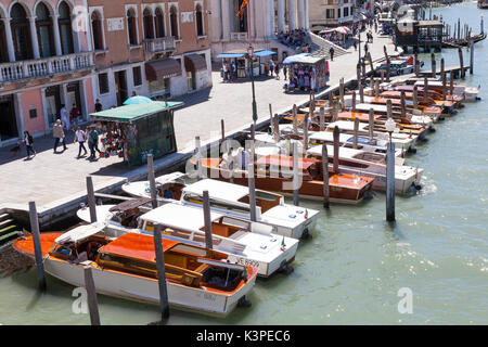 Blick vom Scalzi Brücke eines Venezianischen Stil Taxistand mit einer langen Reihe von günstig Wasser Taxis auf dem Canal Grande, Venedig, Italien, immer bereit für t Stockfoto