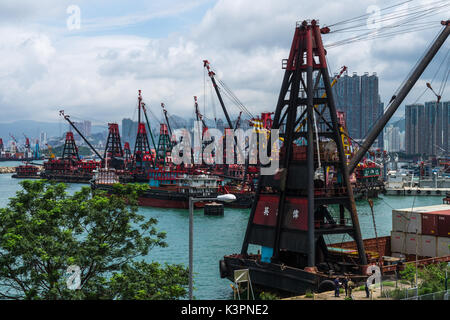 Baggerarbeiten Lastkähne für die Landgewinnung (mit Derrick Krane) in Victoria Harbour und Hong Kong Stockfoto