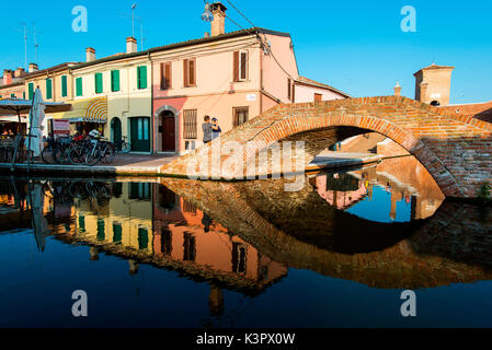 Comacchio, Ferrara, Emilia Romagna, Italien, Europa. Eine alte Brücke zurückgebogen in den Kanal. Stockfoto