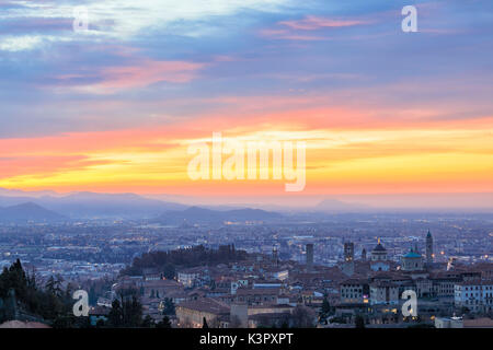 Blick auf die mittelalterliche Altstadt Città Alta auf dem Hügel von den Fiery orange sky im Morgengrauen Bergamo Lombardei Italien Europa gerahmt Stockfoto