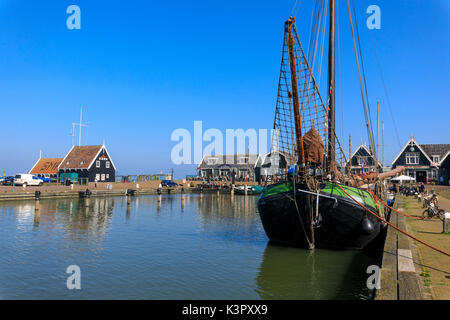 Fischerboote in den Kanal durch den typischen Holzhäusern im Frühjahr Marken Waterland North Holland Niederlande Europa gerahmt Stockfoto