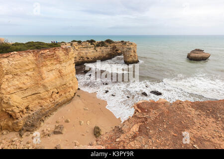 Wellen, die am Sandstrand umgeben von Klippen Albandeira Lagoa Gemeinde Algarve Portugal Europa Stockfoto