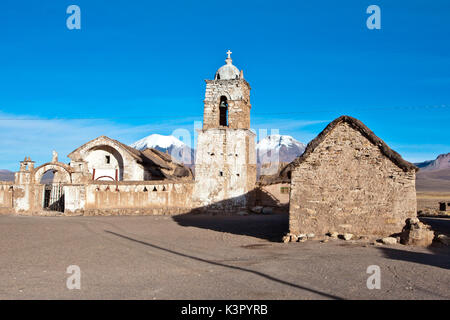 Die Kirche von Sajama und Vulkan Parinacota und Pomerape (Les Nevados de Payachatas). Der Sajama Pueblo, in der Sajama Nationalpark, ist der Ausgangspunkt für die Besteigung des Nevado Sajama, der höchste Gipfel in Bolivien (6542 m) - Bolivien, Südamerika Stockfoto