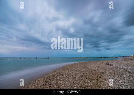 Gewitterwolken sind in das klare Wasser bei Sonnenuntergang Porto Recanati Provinz Macerata Riviera del Conero Marche Italien Europa wider Stockfoto