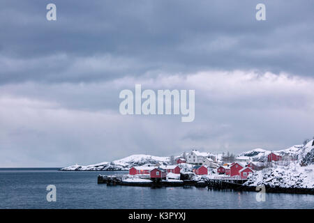 Kalte Meer und schneebedeckten Gipfeln Frame das Fischerdorf in der Dämmerung Nusfjord Lofoten Nordland Nordnorwegen Europa Stockfoto