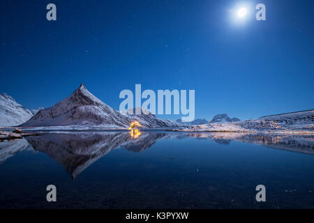 Volle Mond und Sterne leuchten die schneebedeckten Gipfel im Meer Volanstinden Fredvang Lofoten in Nordnorwegen Europa Stockfoto