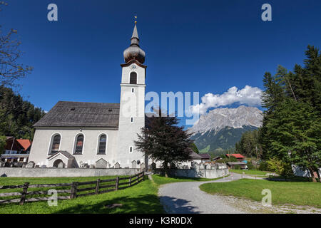 Typische Kirche alpinen Dorfes umgeben von Gipfeln und Wald Garmisch Partenkirchen Oberbayern Region Bayern Deutschland Europa Stockfoto