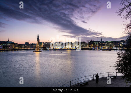 Die Farben und das Licht der Dämmerung auf der Binnenalster mit dem Weihnachtsbaum in seinem Wasser Hamburg Deutschland Europa ausgesetzt Stockfoto