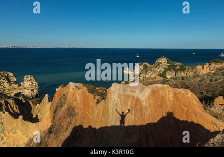 Der Schatten der Silhouette der Wanderer auf den Klippen umgebenden Strand Praia Dona Ana Lagos Algarve Portugal Europa Stockfoto