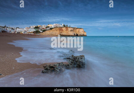 Ozean-Wellen, die auf Felsen und Strand rund um Carvoeiro Dorf bei Sonnenuntergang Lagoa Gemeinde Algarve Portugal Europa Stockfoto