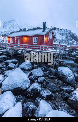 Typische Fischerhäuser genannt Fischerorten in die verschneite Landschaft in der Abenddämmerung Nusfjord Nordland County Lofoten Inseln Norwegen Europa Stockfoto