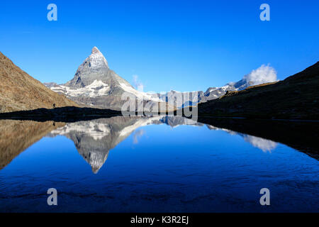 Wanderer bewundert das Matterhorn im See Stellisee Zermatt im Kanton Wallis Walliser Alpen Schweiz Europa wider Stockfoto