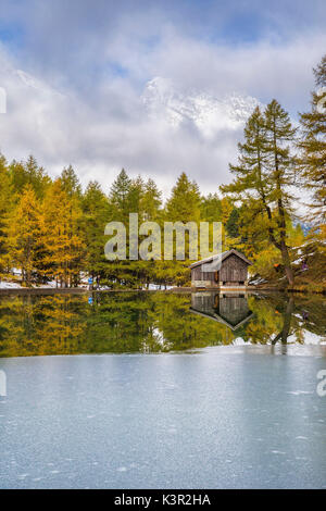 Holzhütte und bunte Bäume spiegeln sich im Lai da Palpuogna Albula Pass Bergün Kanton Graubünden-Engadin-Schweiz-Europa Stockfoto