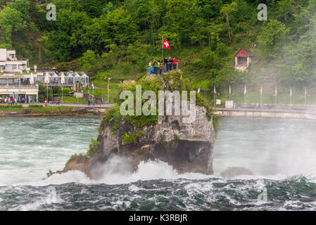 Neuhausen am Rheinfall, Schweiz - 24. Mai 2016: Touristen auf einem Felsen über dem Rheinfall in Neuhausen am Rheinfall, Schaffhausen, Schweiz. Die Stockfoto