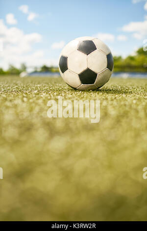 Nahaufnahme der Ball liegt auf grünem Gras in Leer Fußball Feld Stockfoto