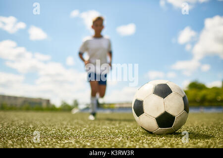 Portrait von unkenntlich Teenager im Bereich der Kugel während Fußball-Praxis zu treten, den Schwerpunkt auf die Kugel Stockfoto