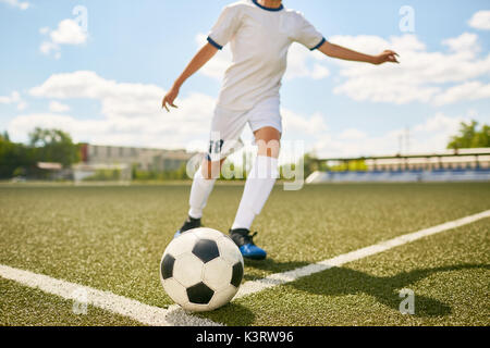 Portrait von unkenntlich Teenager treten Kugel während der Fußball-Praxis im Feld im Freien Stockfoto