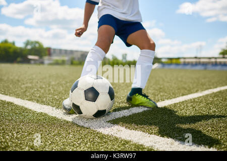 Closeup Portrait von unkenntlich Teenager treten Kugel während der Fußball-Praxis im Feld im Freien Stockfoto