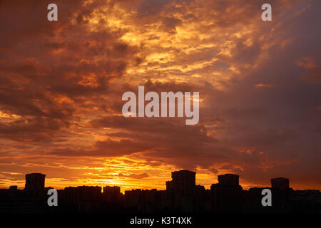 Schöner Sonnenuntergang Szene in der Stadt mit dunklen Silhouetten von Gebäuden Stockfoto