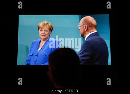 Berlin, Deutschland. 3. Sep 2017. Ein Mensch beobachtet das TV-Duell zwischen Bundeskanzlerin Angela Merkel und Martin Schulz, Kanzler Kandidat der Sozialdemokratischen Partei (SPD), zu einem Media Center in Berlin, Deutschland, Sept. 3, 2017. Die deutsche Bundeskanzlerin Angela Merkel sagte Sonntag Nacht im TV-Duell mit Martin Schulz, obwohl die "radikale Islamisten der Verübung terroristischer Akte in Europa sind, sie glaubt immer noch, dass "der Islam gehört zu Deutschland." Quelle: Shan Yuqi/Xinhua/Alamy leben Nachrichten Stockfoto