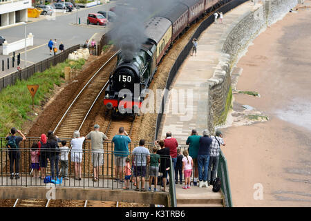 Menschen beobachten den Dampfzug des Königlichen Herzogtums, der durch Dawlish fährt, gezogen von LMS 4-6-0 No 46100 'Royal Scot', am 6.. August 2017. Stockfoto