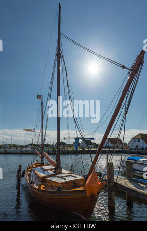 Hölzerne Segelboot im Hafen von Neuendorf auf der Insel Hiddensee beleuchteten, von der Sonne mit sunstars, Mecklenburg-Vorpommern, Deutschland Stockfoto