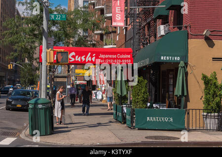 New York, NY, USA August 3, 2016 - Foto von Fußgängern und bunten Restaurants an der Ecke der West 22. Straße und 7th Avenue in Manhattan. Editori Stockfoto