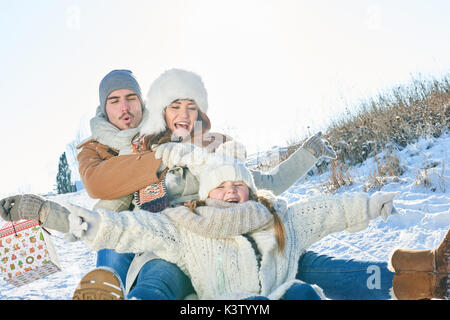 Familie Spaß mit Schlitten auf dem Schnee im Winter Stockfoto